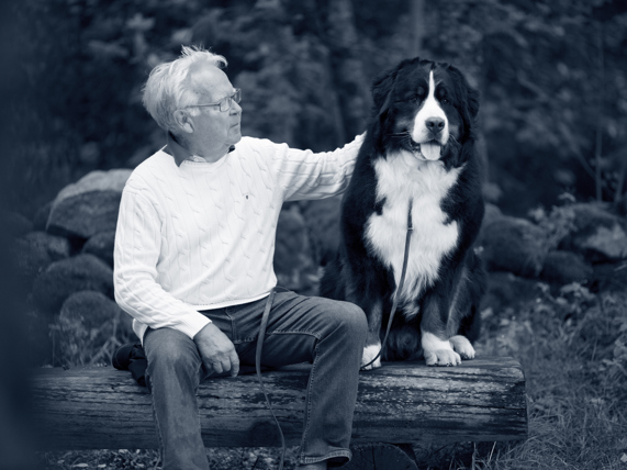 Oude man en hond zitten samen op een bank