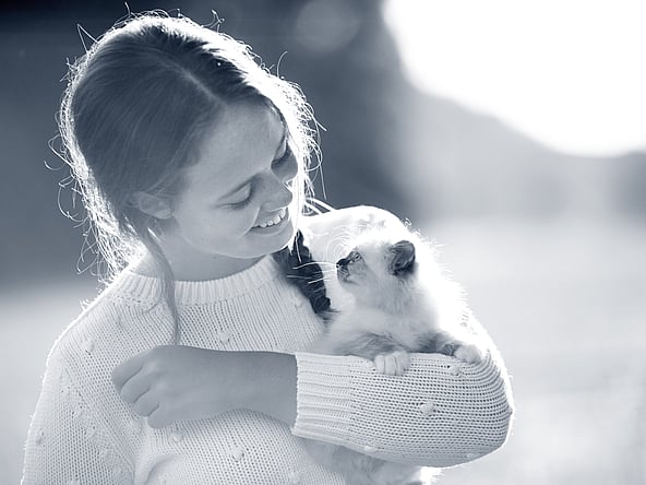 Een kind dat een kat vasthoudt.