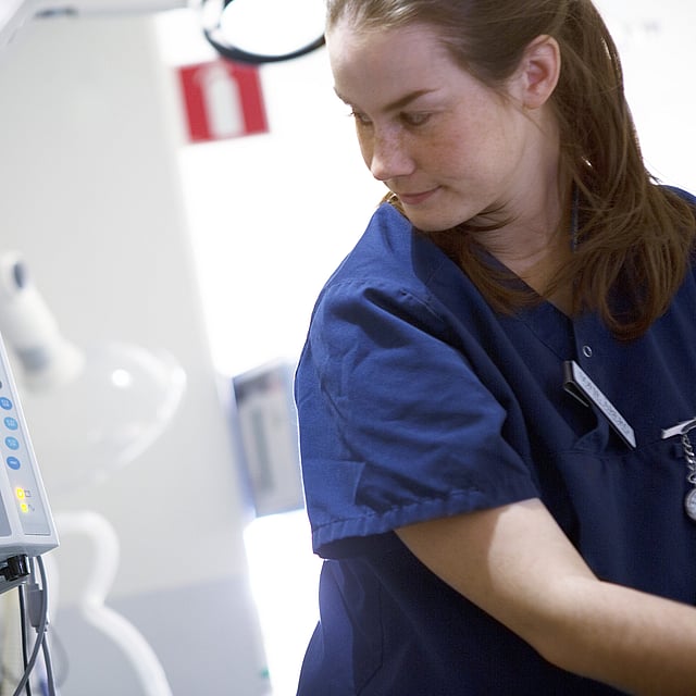 Een persoon in scrubs die een monitor bekijken.