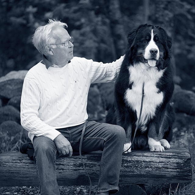 Oude man en hond zitten samen op een bank