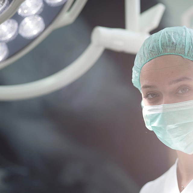 Een persoon met een masker en pet.