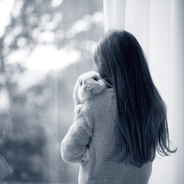 Meisje knuffelt konijn