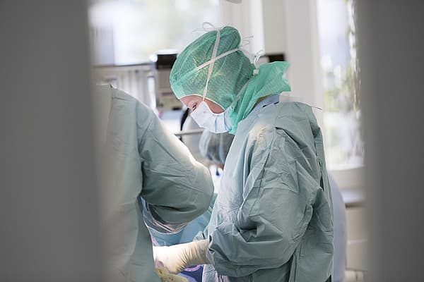 Een groep mensen die chirurgisch materiaal dragen.