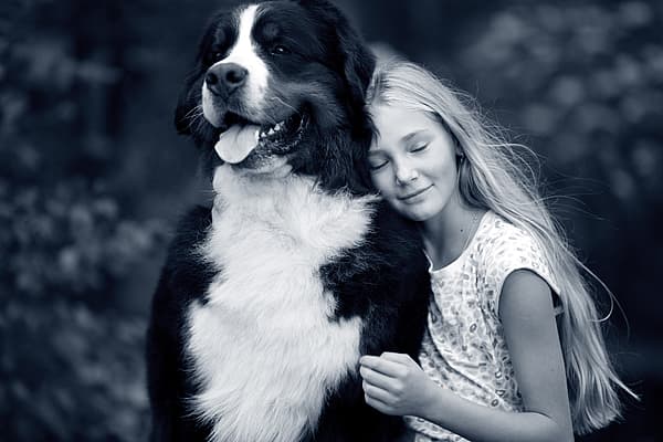 Een kind dat een hond koestert.