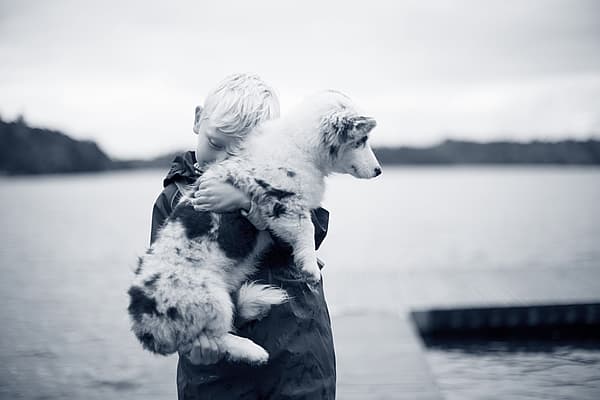 Een kind dat een hond vasthoudt.