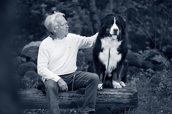 Oude man en hond zitten samen op een bank