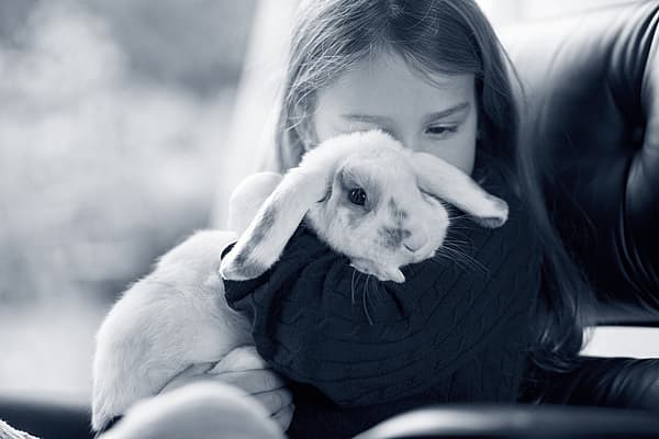 Meisje knuffelt grote konijn