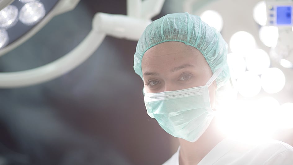 Een persoon met een masker en pet.