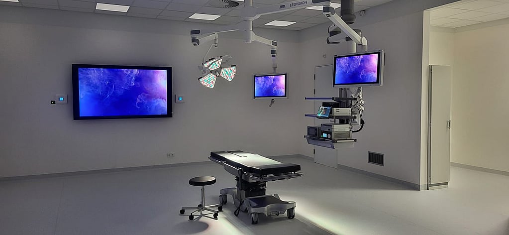 Een kamer met een bed en monitoren.